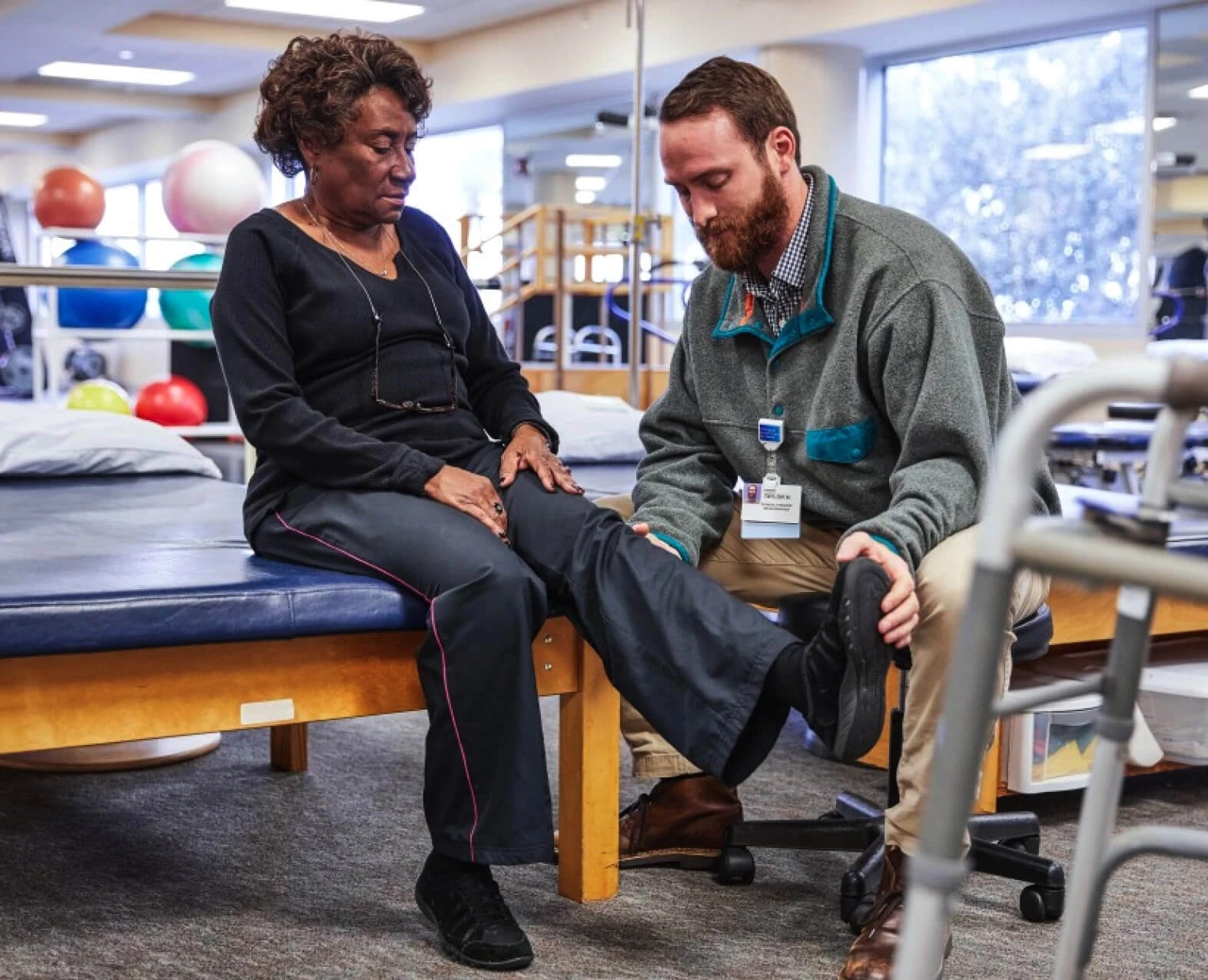 A physical therapist assisting an elderly woman during a rehabilitation session. (photo)