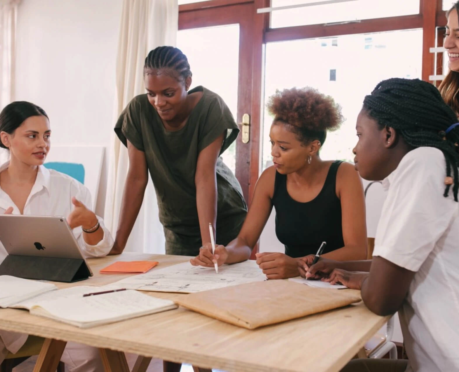 A group of women collaborating around a table. (photo)