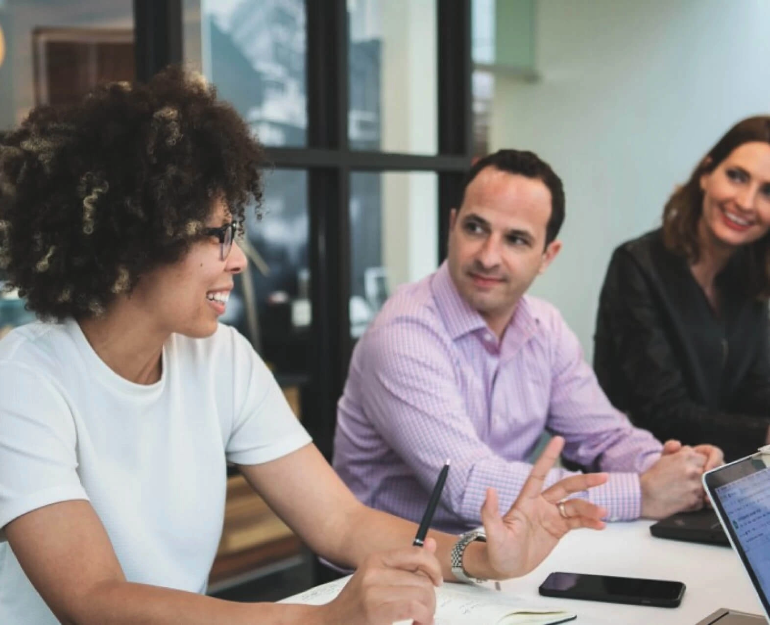 A group of three colleagues having a discussion at a meeting table. (photo)