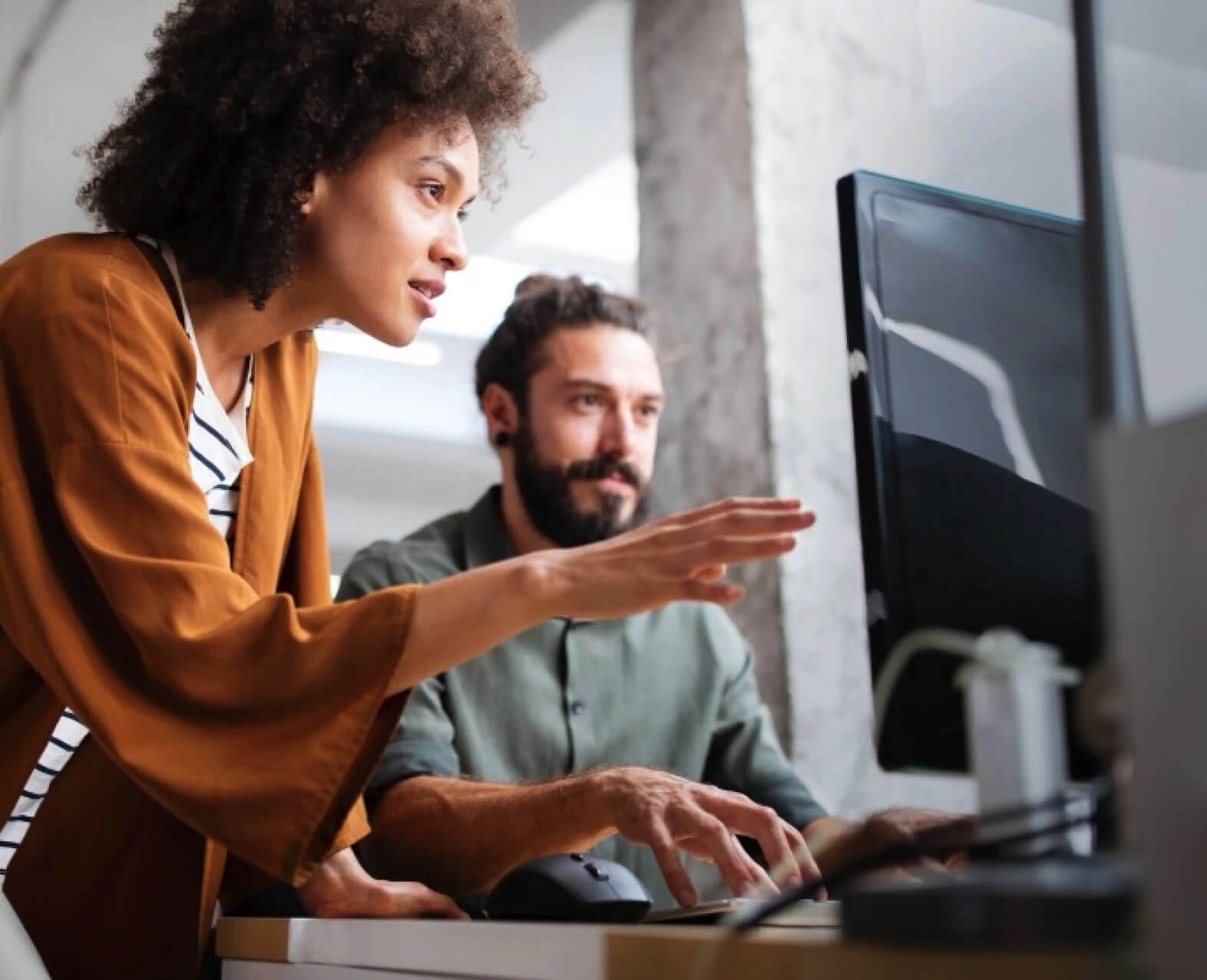 Two colleagues discussing and looking at a computer screen. (photo)