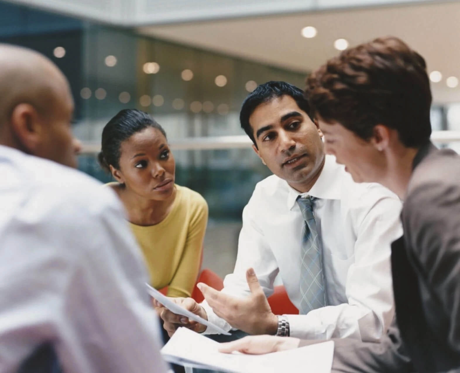 A group of professionals having a discussion in a modern office setting. (photo)