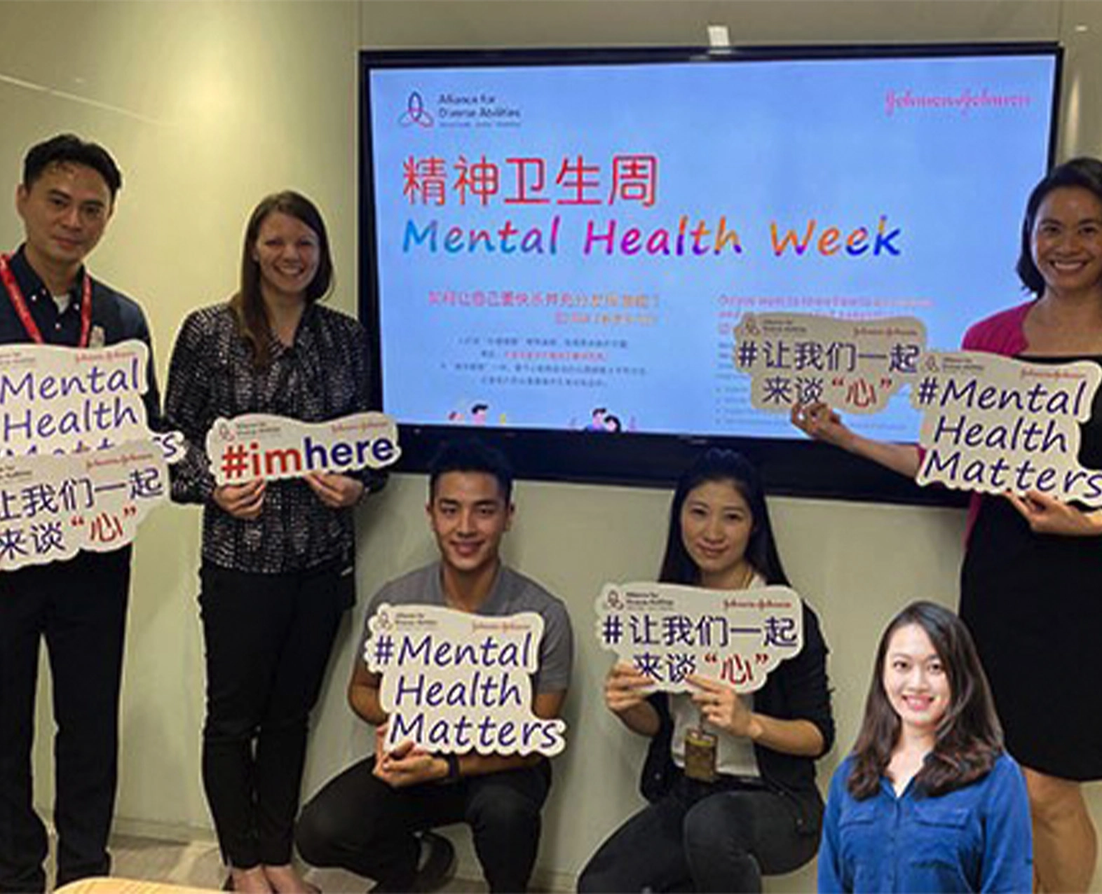 A group of people holding signs promoting mental health awareness during Mental Health Week. (photo)